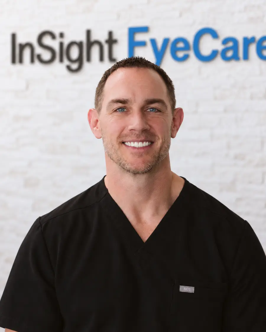 Dr. Mark Sturm, optometrist at InSight EyeCare, in front of the InSight EyeCare wall sign at the Cibolo office.